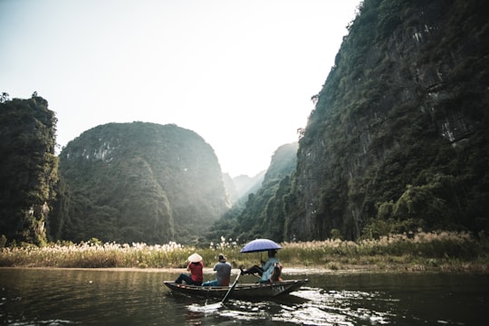 2 person riding on boat on river during daytime in Ninh Bình Vietnam
