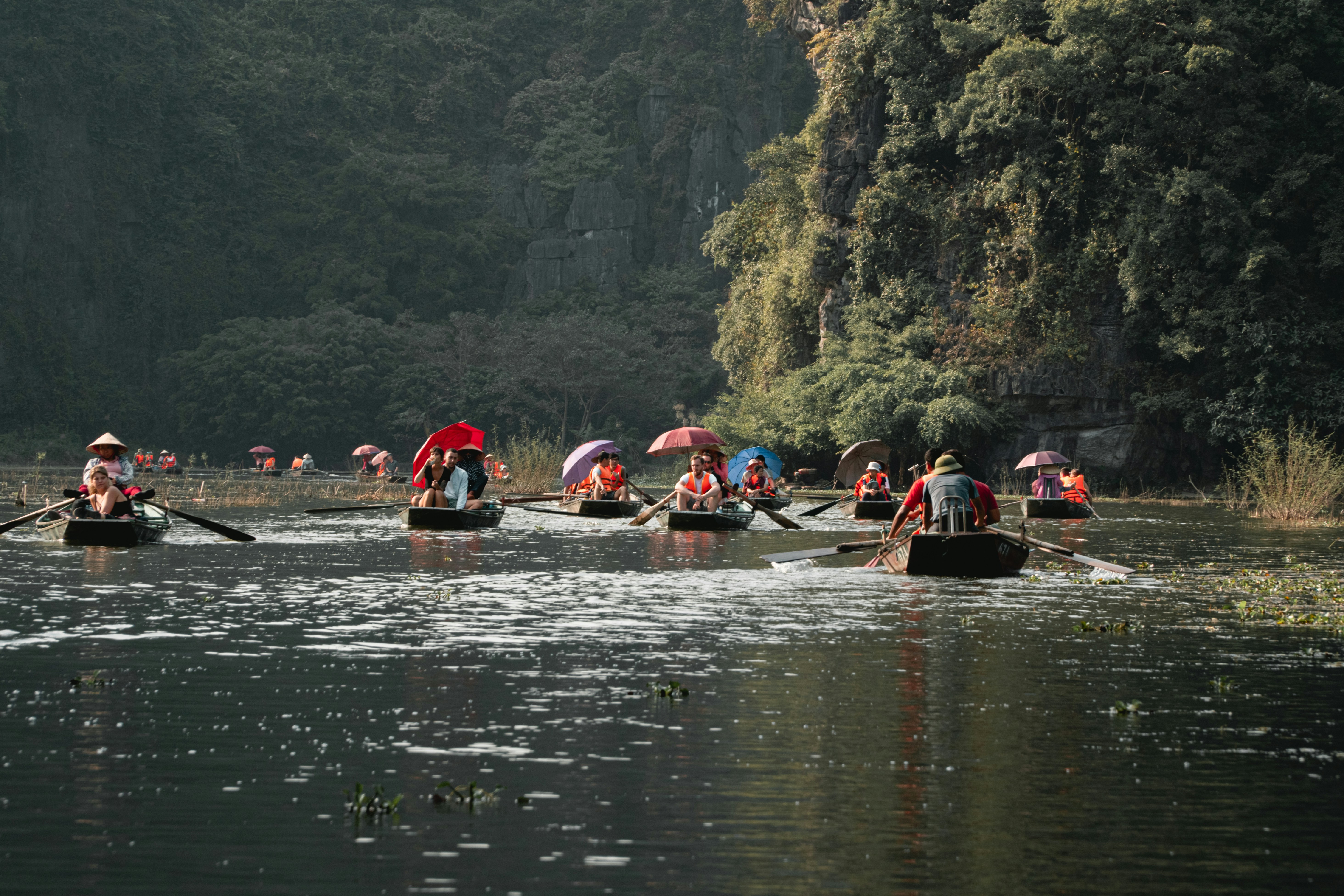 people riding on red kayak on river during daytime