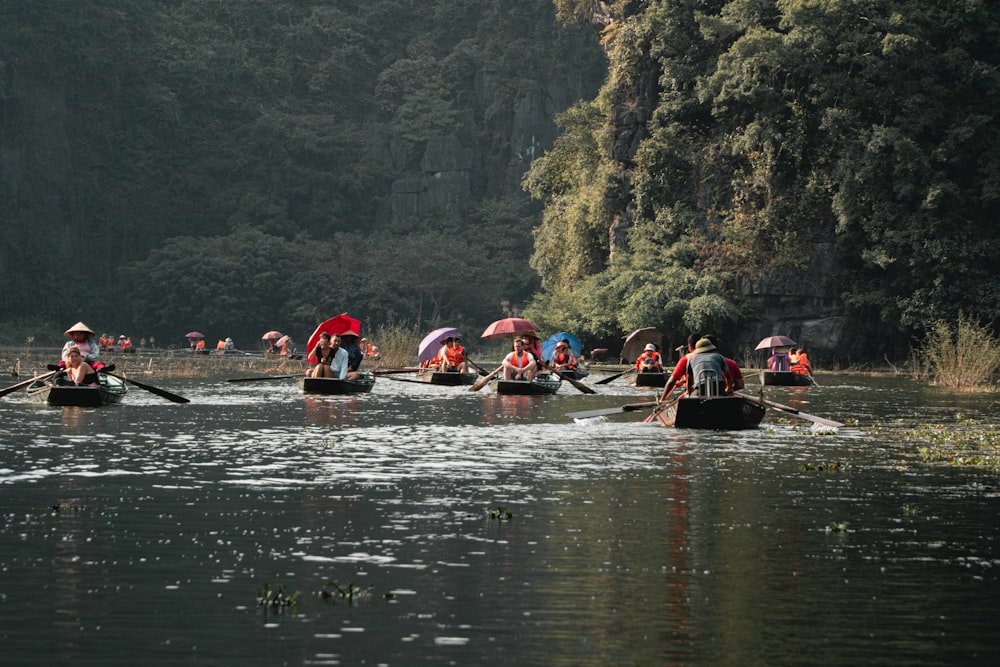 people riding on red kayak on river during daytime