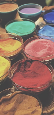 Bowl of colorful fruit and vegetable powders arranged neatly on a rustic wooden table.