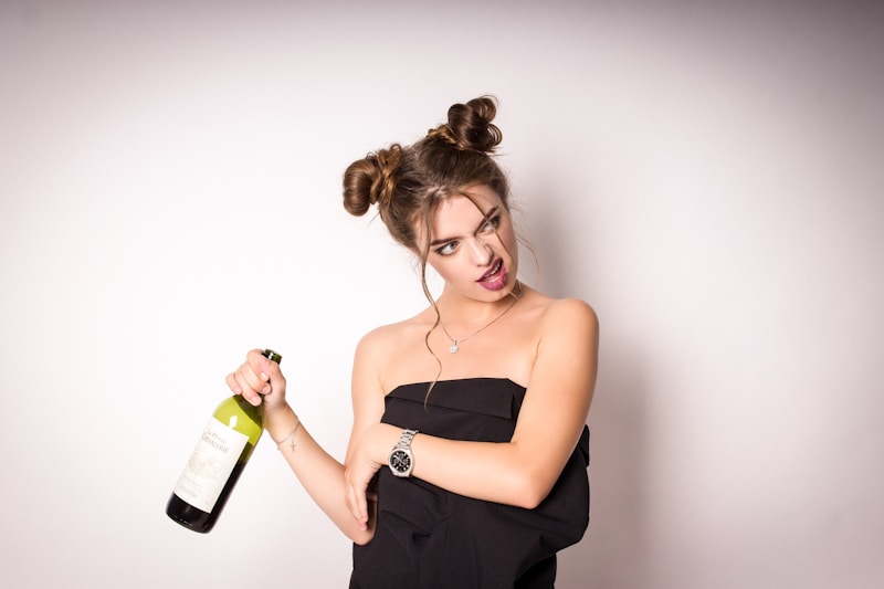 Mujer con top negro y botella verde