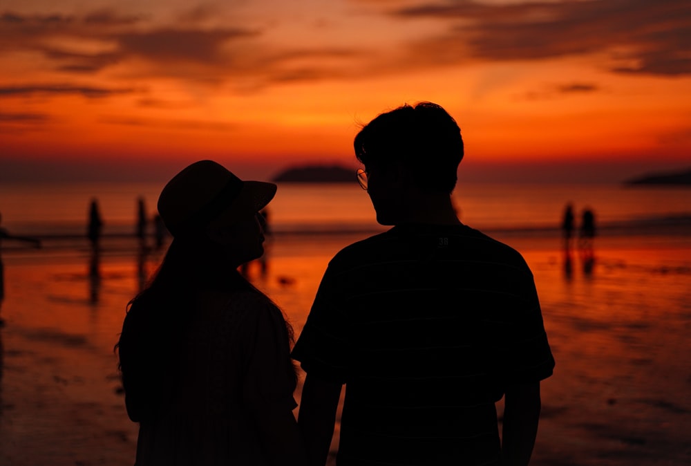 silhouette of 2 men standing during sunset