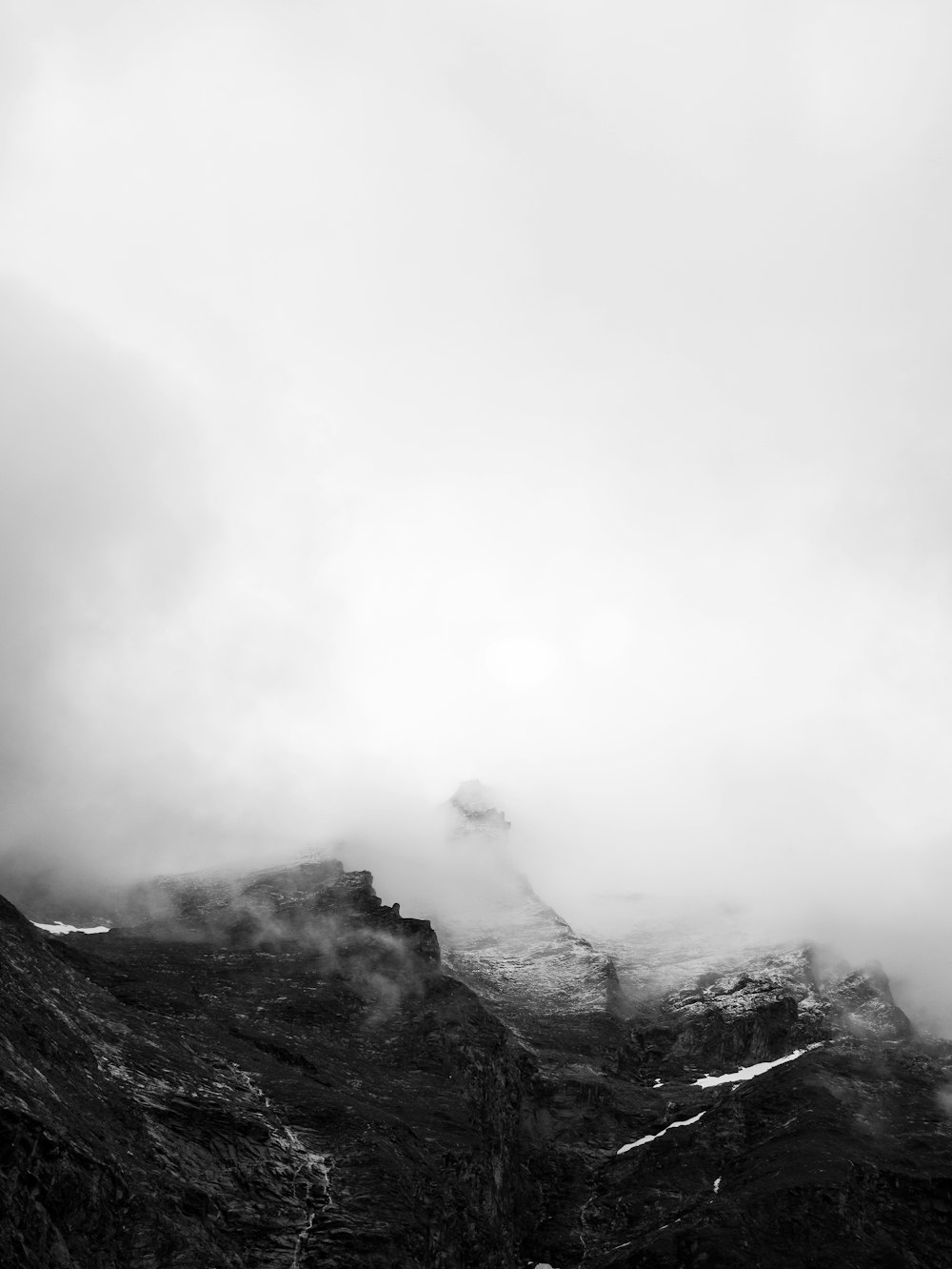 grayscale photo of foggy mountain