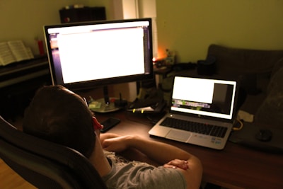 Close-up of Sasha Cvetko analyzing data on multiple sleek screens in a minimalist, high-contrast office.