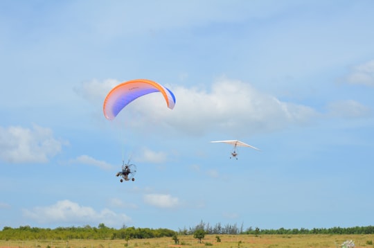 people riding on yellow and red parachute during daytime in Phan Thiet Vietnam