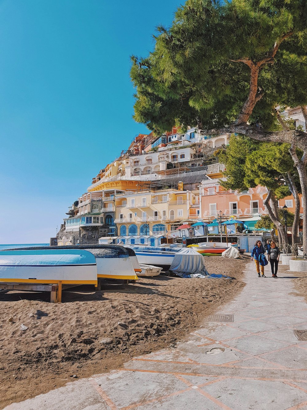 people walking on beach near houses during daytime