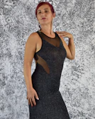 Model wearing a chic red dress paired with elegant black shapewear in a minimalist setting.