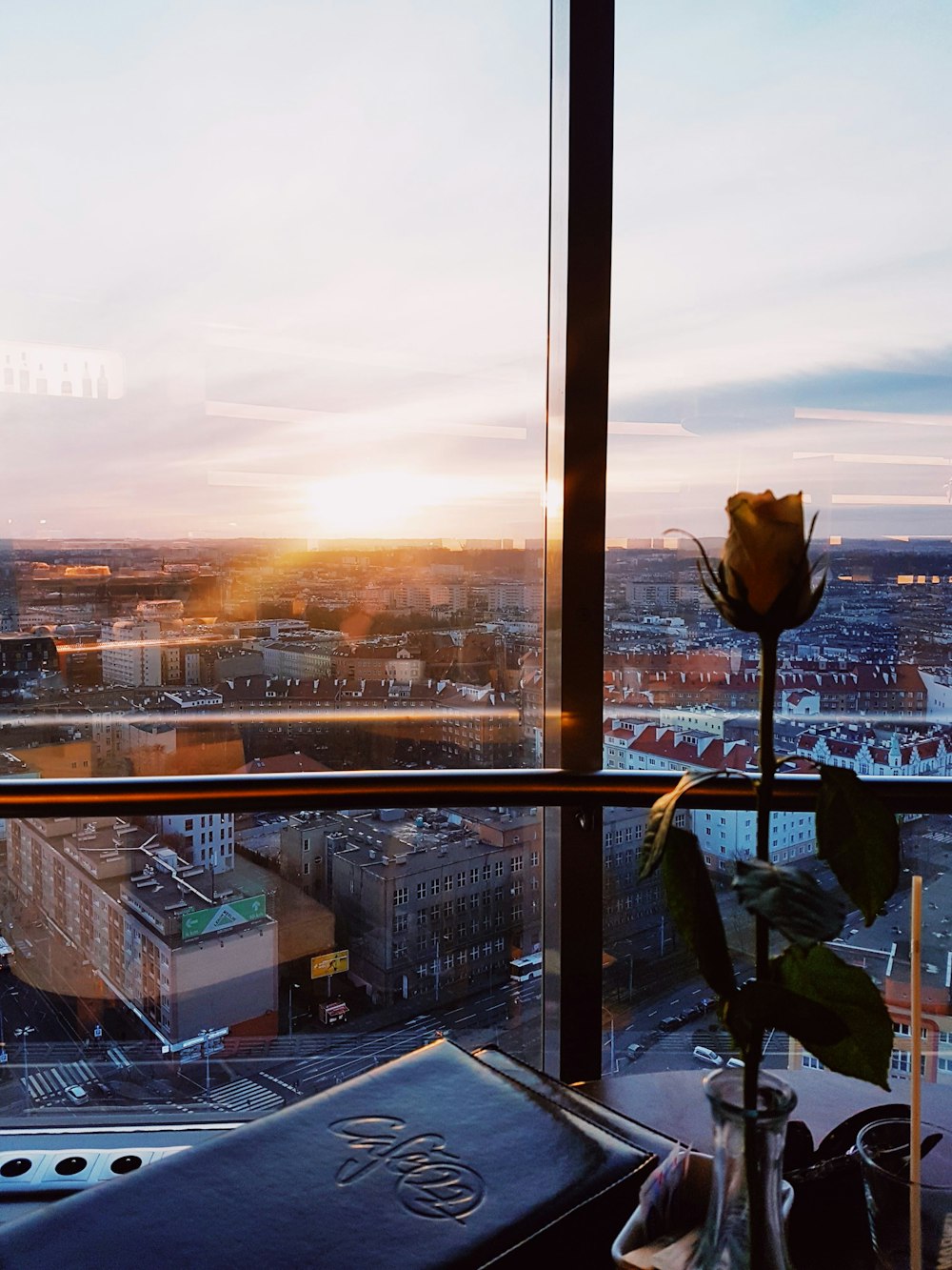 man in blue jacket sitting on chair near glass window during sunset