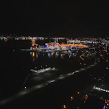 Aerial view of a smart city with illuminated port and terminal infrastructure at dusk.
