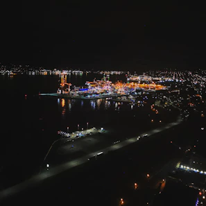 Aerial view of a smart city with illuminated port and terminal infrastructure at dusk.