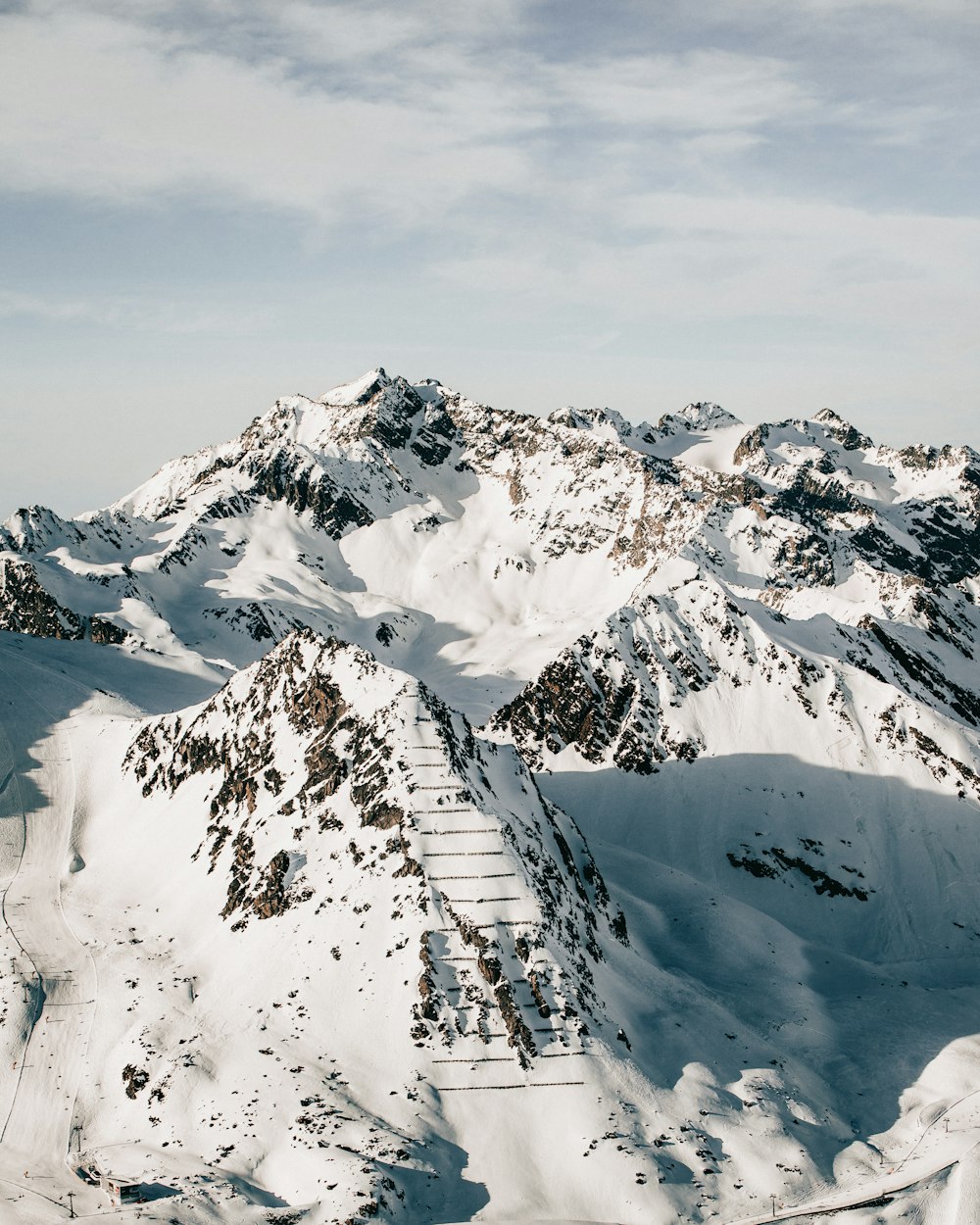 snow covered mountain under cloudy sky during daytime