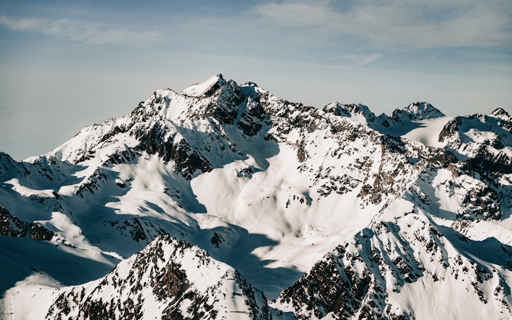 a mountain range covered in snow under a blue sky