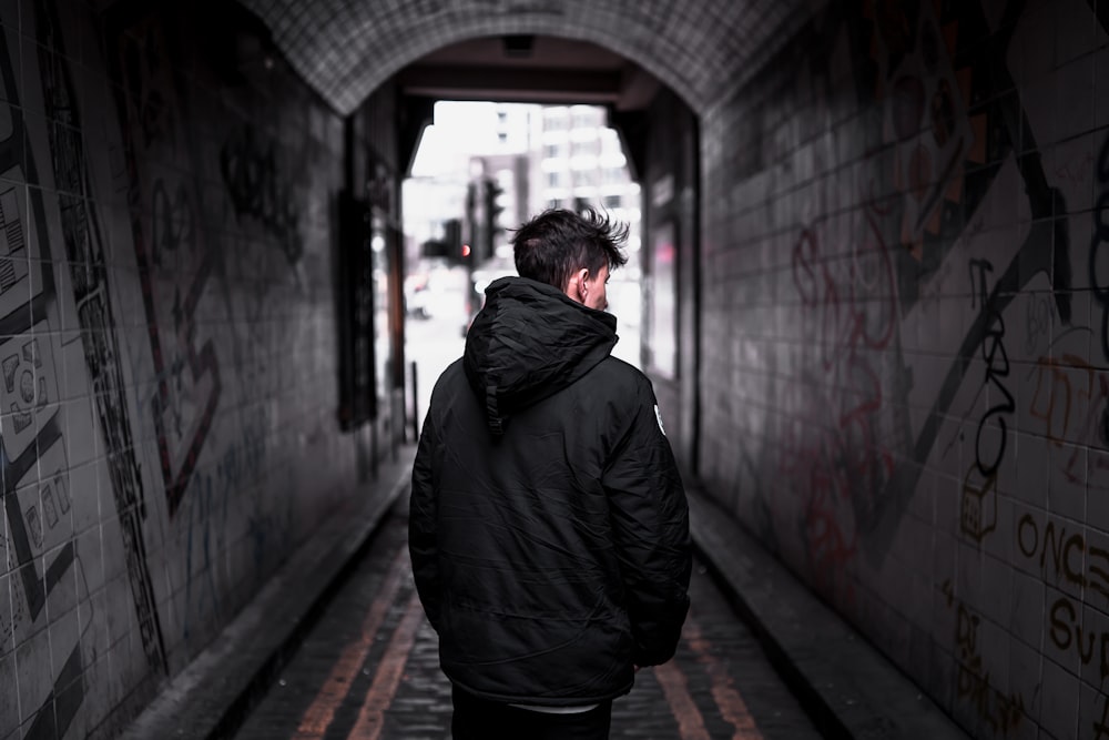 man in black jacket standing on hallway