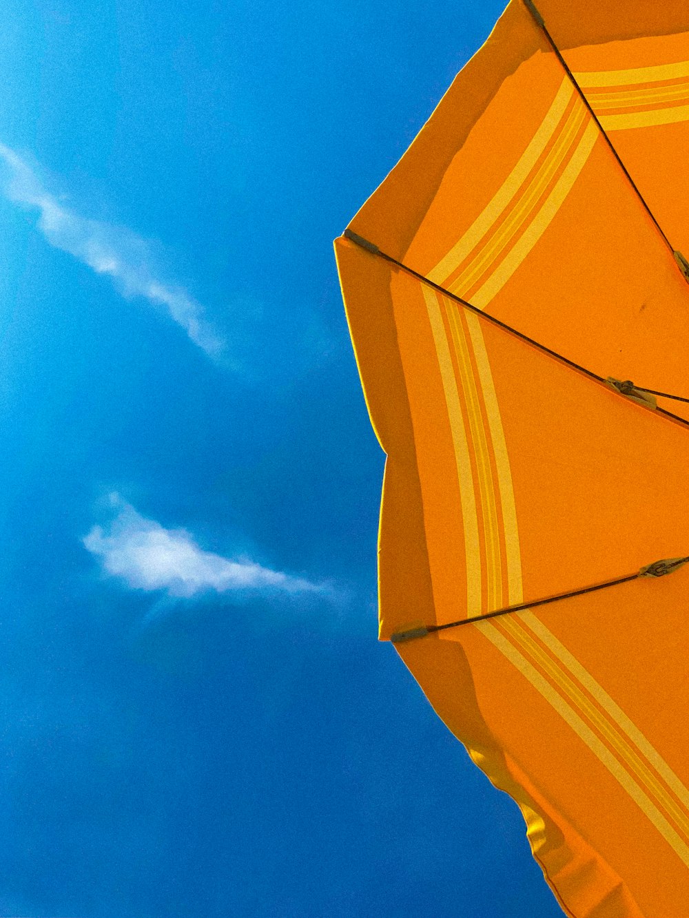 Gelber Regenschirm unter blauem Himmel tagsüber
