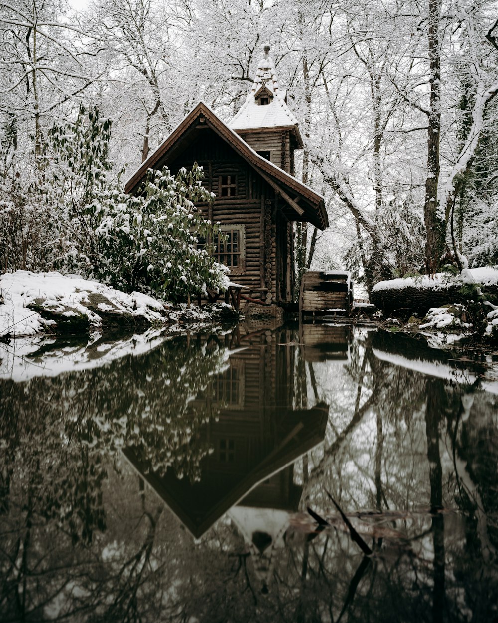 brown wooden house near lake during daytime