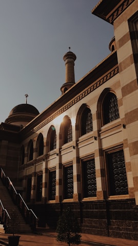 The peaceful exterior of Al-Madarsa Tul Islamia bathed in morning sunlight, showcasing its welcoming entrance.