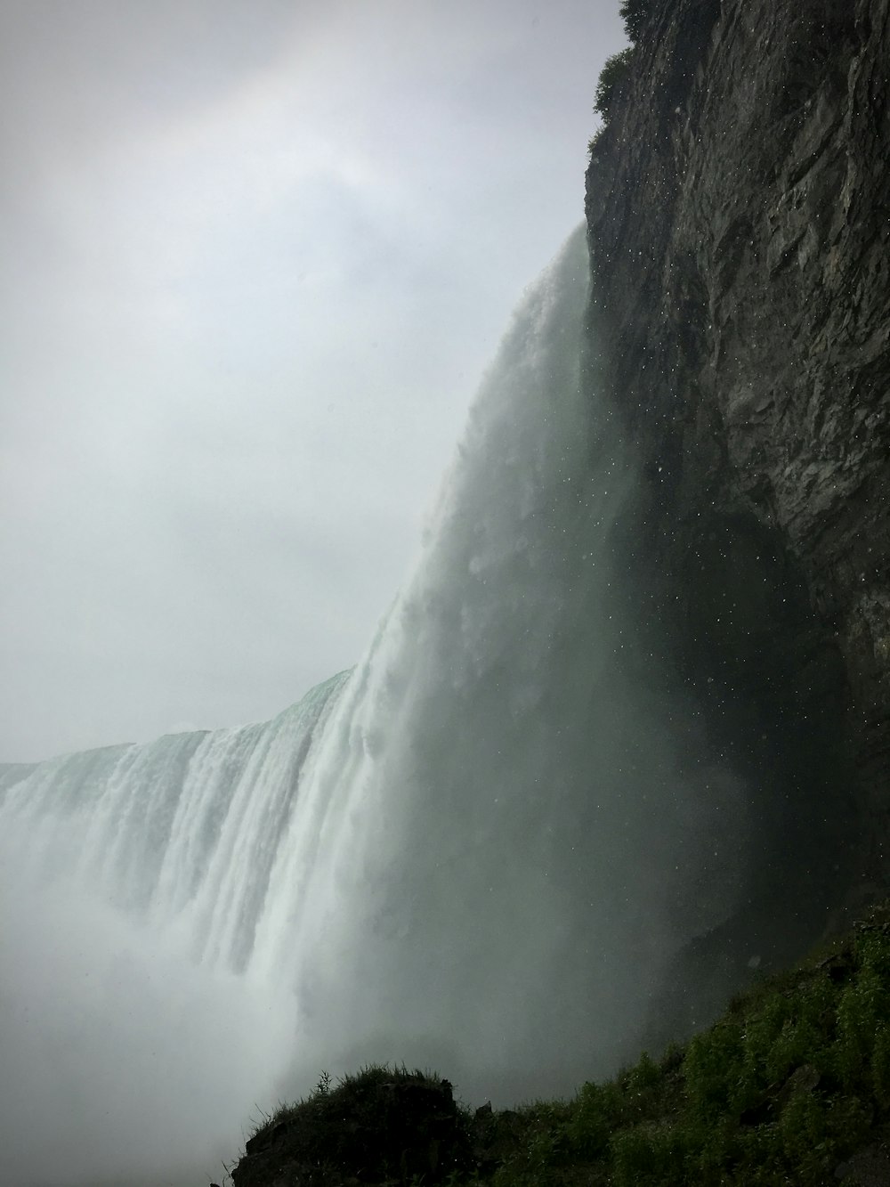 waterfalls under white cloudy sky during daytime