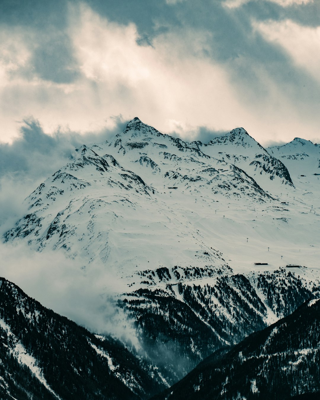 snow covered mountain under cloudy sky during daytime