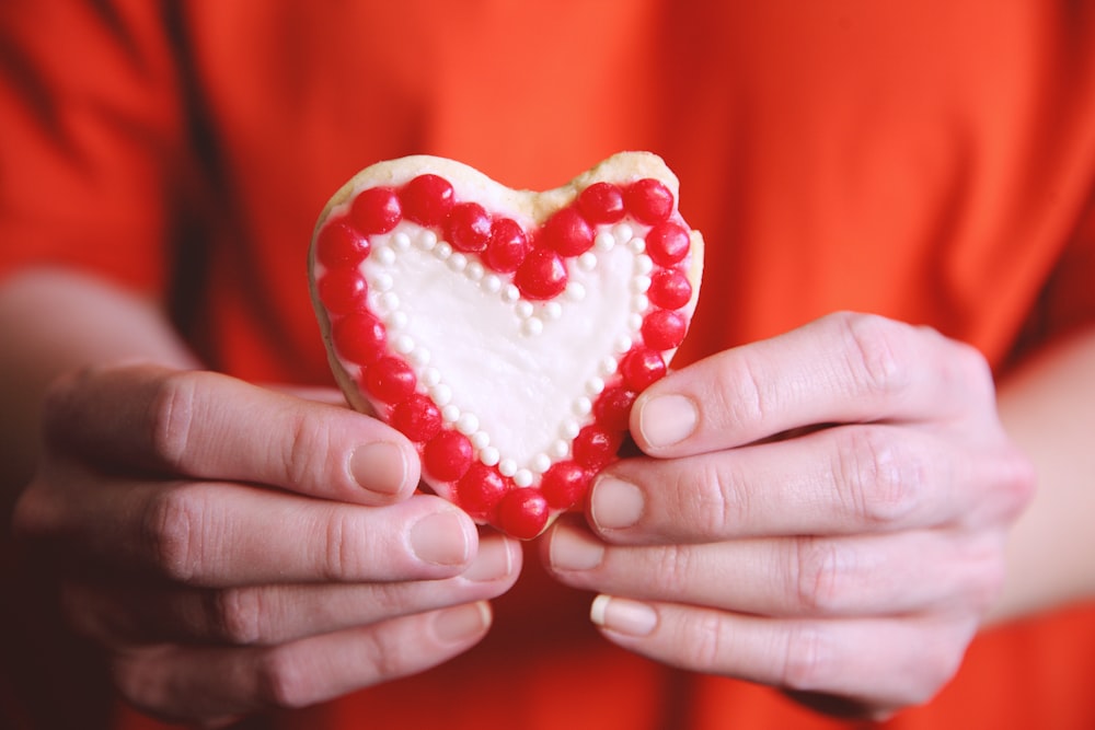 person holding heart shaped red heart shaped ornament