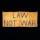 A large yellow fabric banner with bold black letters displaying the message 'LAW NOT WAR' against a dark background.
