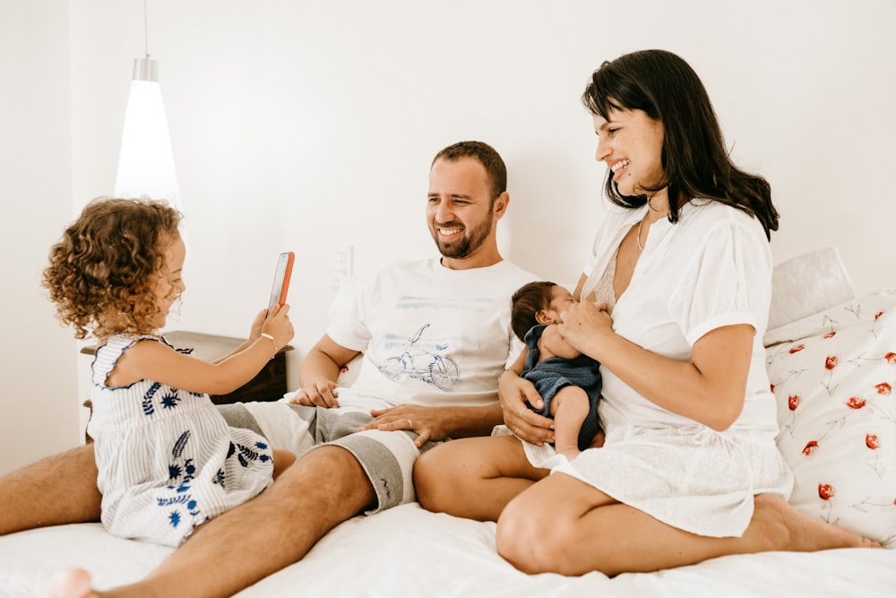 Hombre en camiseta blanca de cuello redondo sentado al lado de mujer en camiseta blanca de cuello redondo