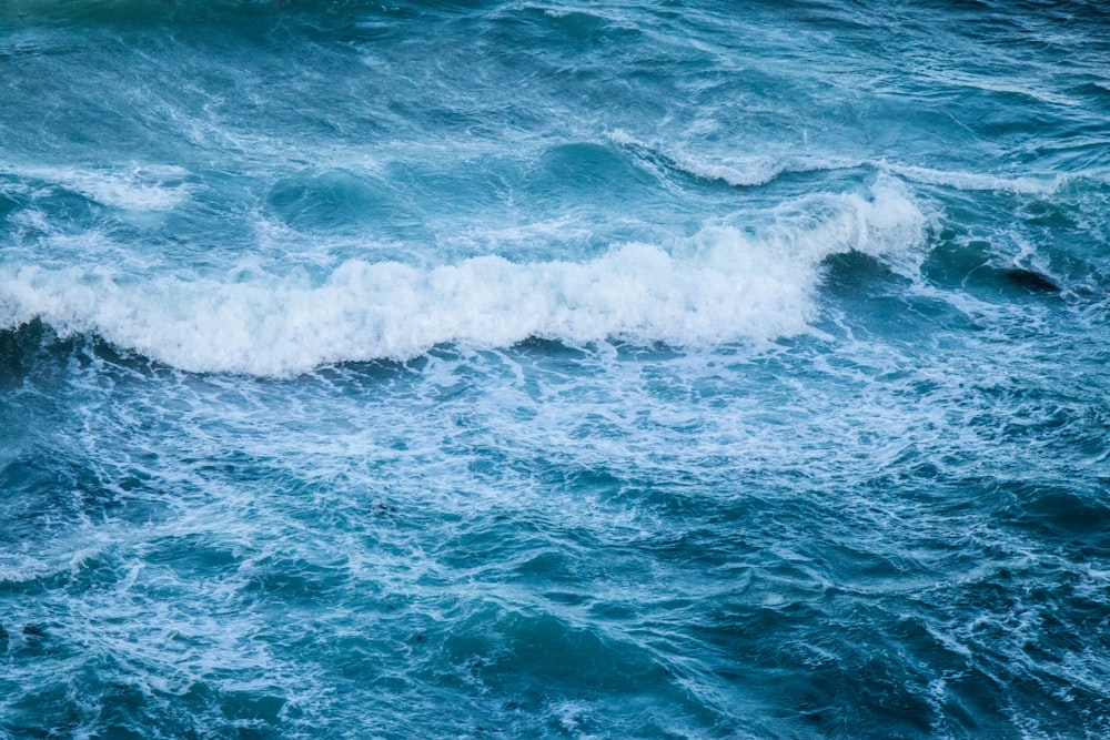 ocean waves crashing on shore during daytime