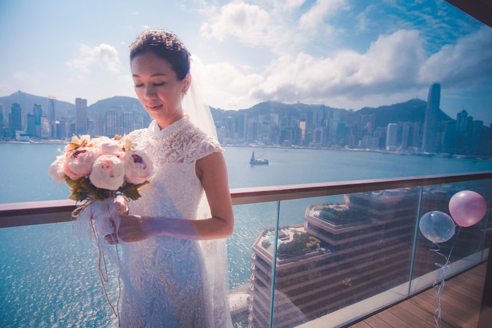 woman in white sleeveless dress holding white and brown dog