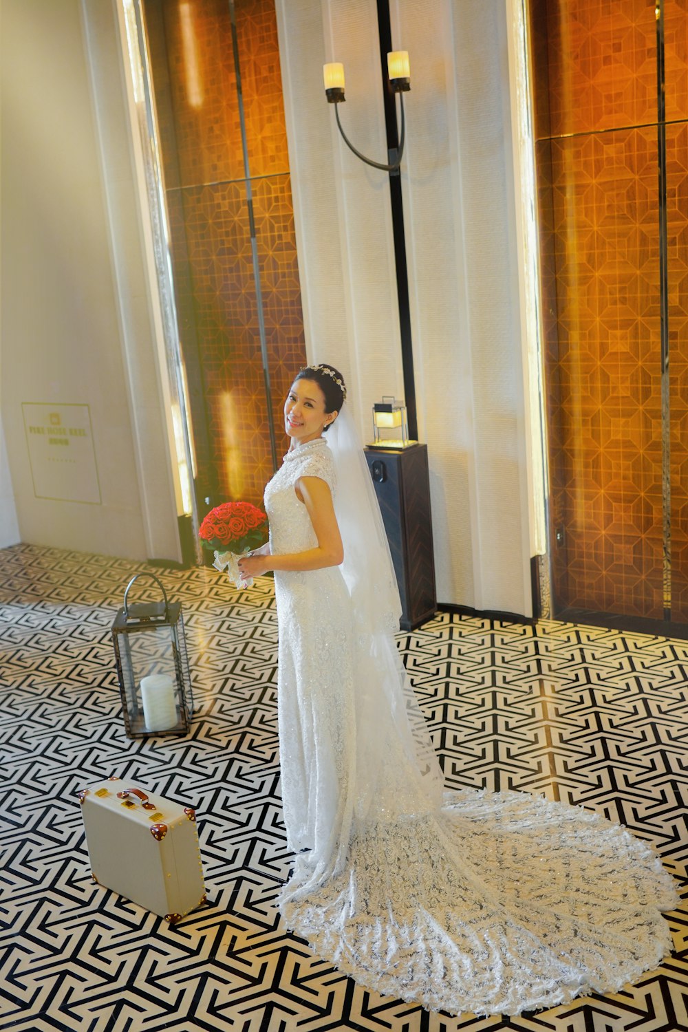 갈색과 흰색 카펫에 서 있는 하얀 웨딩 드레스를 입은 여자