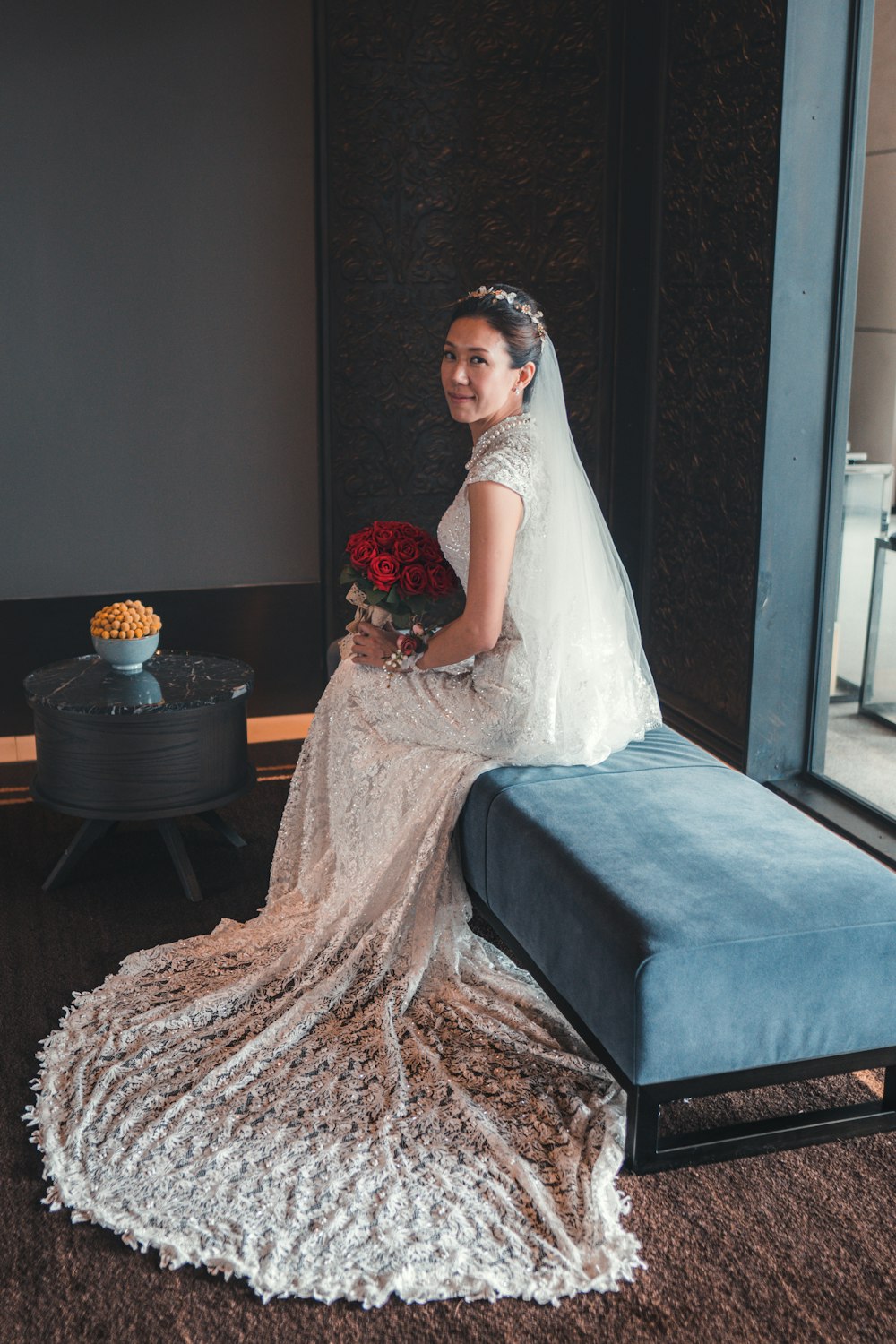 woman in white wedding dress sitting on blue couch