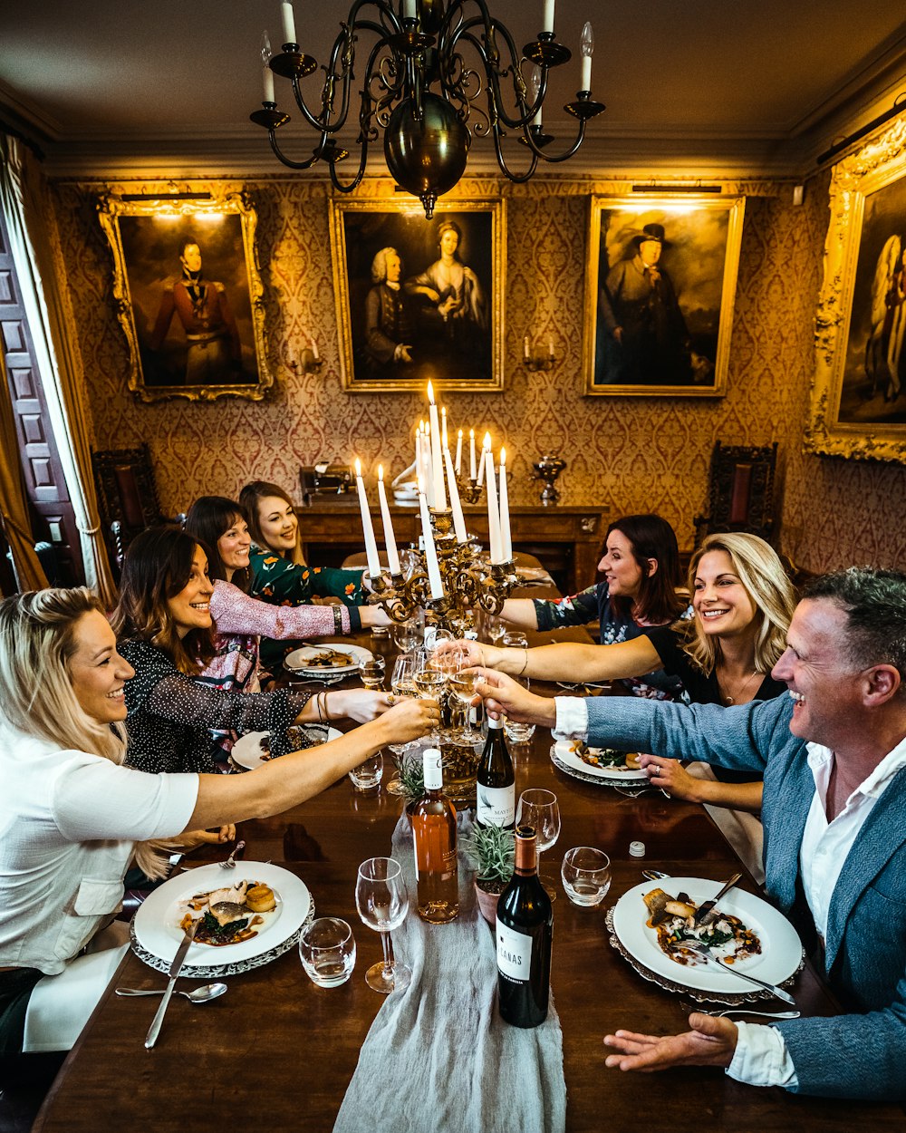 grupo de personas sentadas en una silla frente a la mesa con platos y vasos