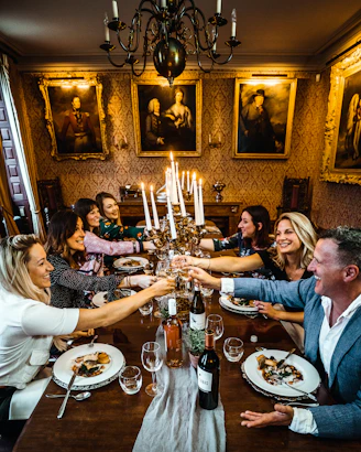 group of people sitting on chair in front of table with plates and drinking glasses