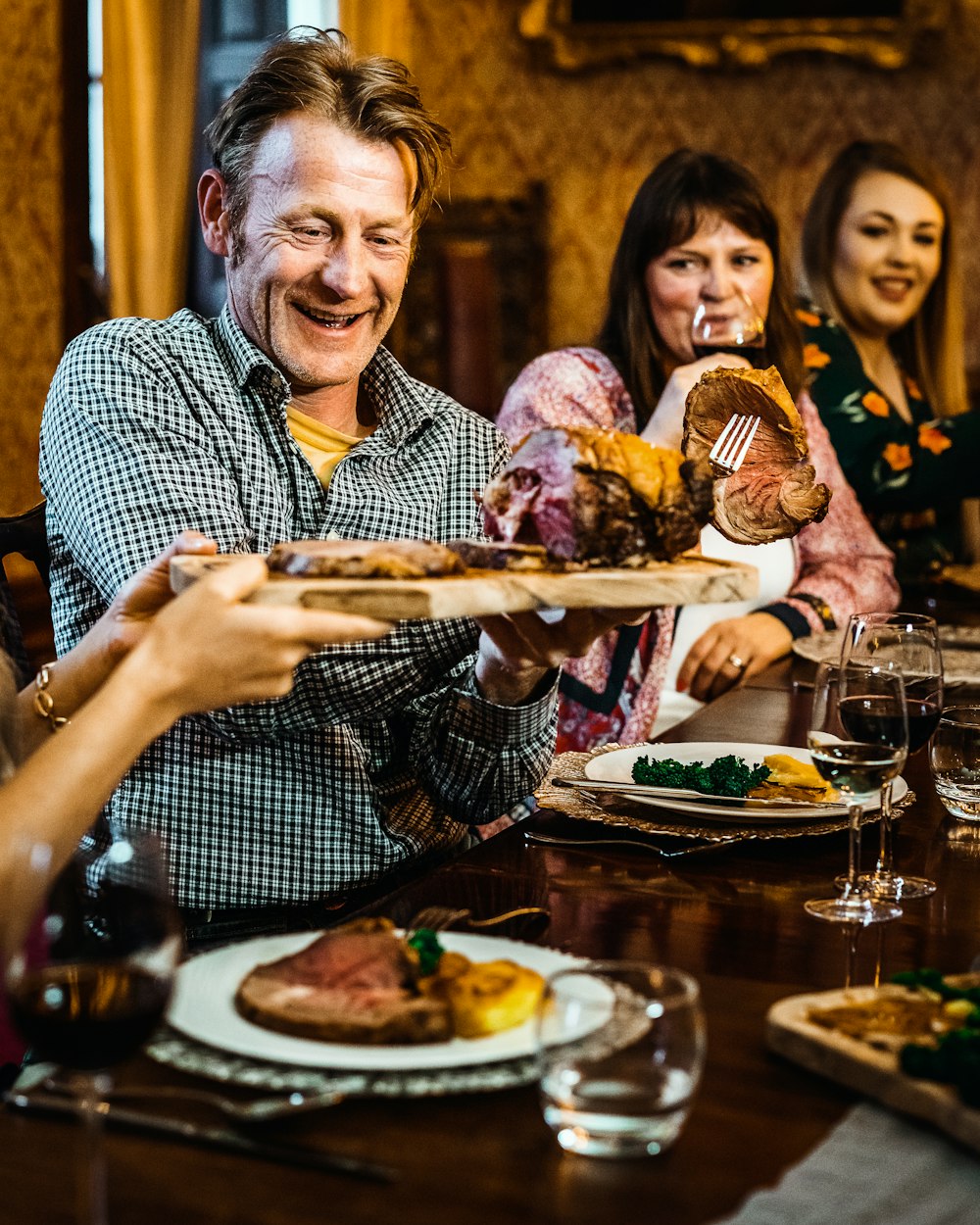 man in blue and white checkered button up shirt holding bread