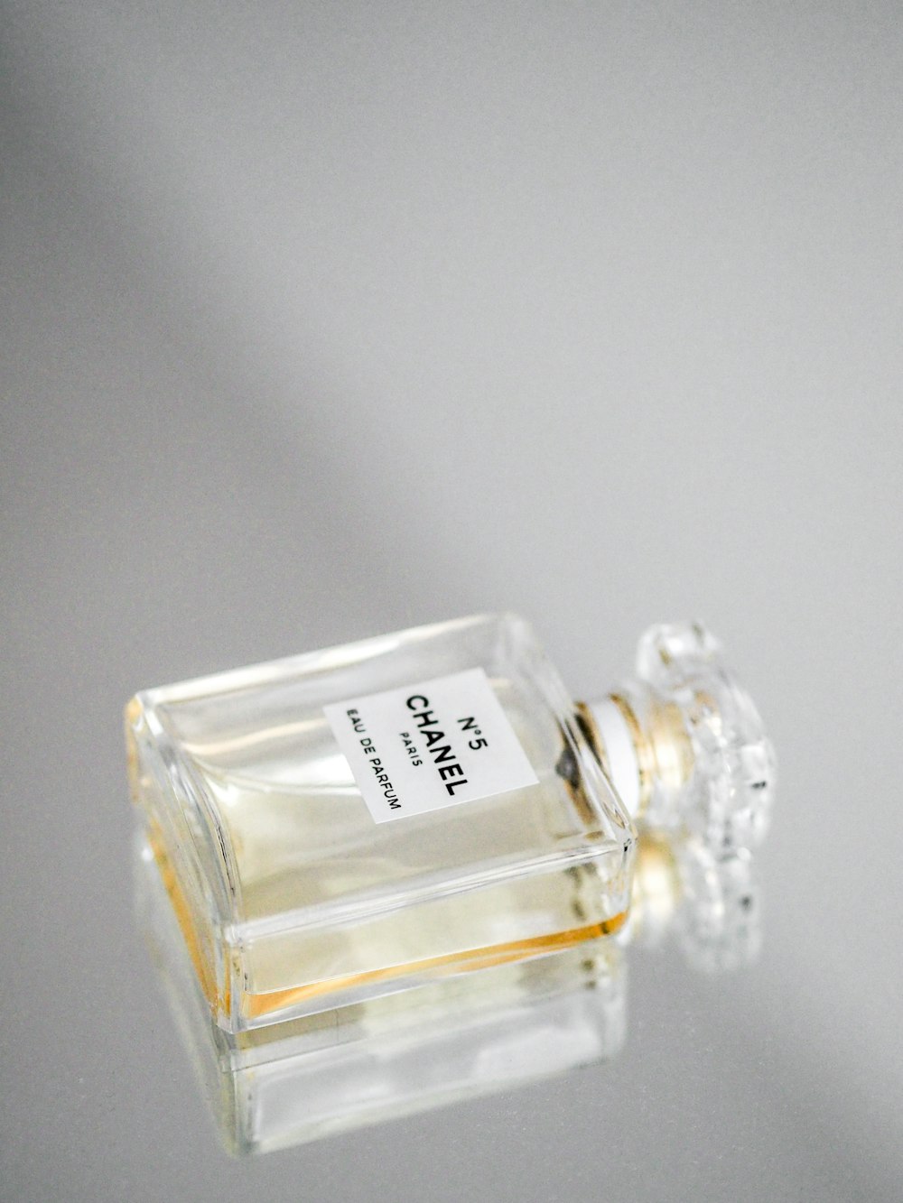 clear glass perfume bottle on white table
