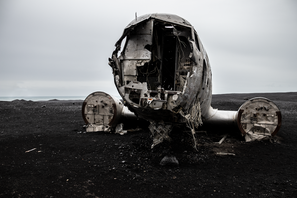 wrecked gray and brown ship on gray sand during daytime