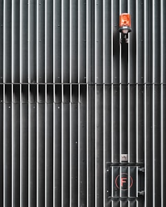 black and red fire extinguisher on gray metal wall