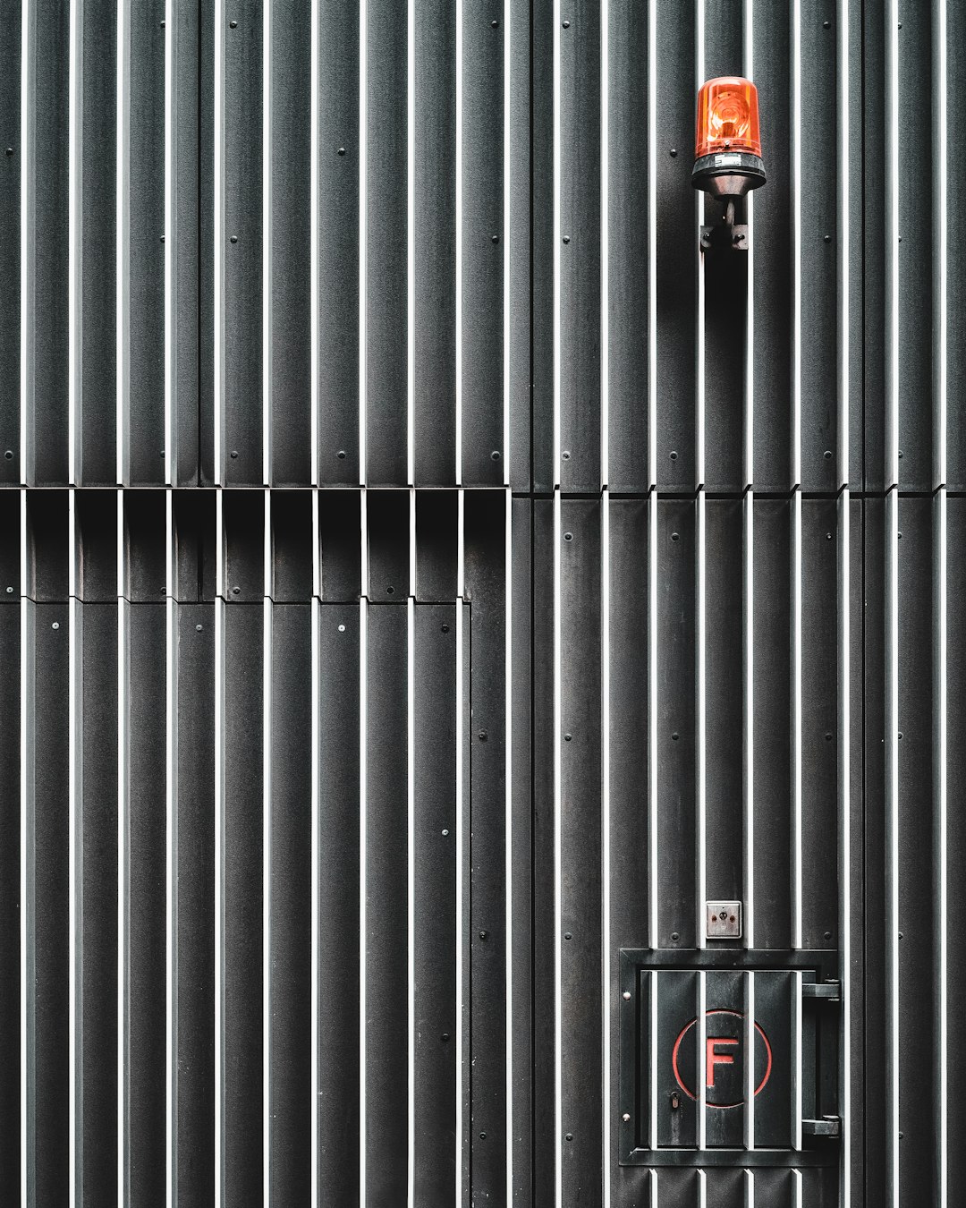 black and red fire extinguisher on gray metal wall