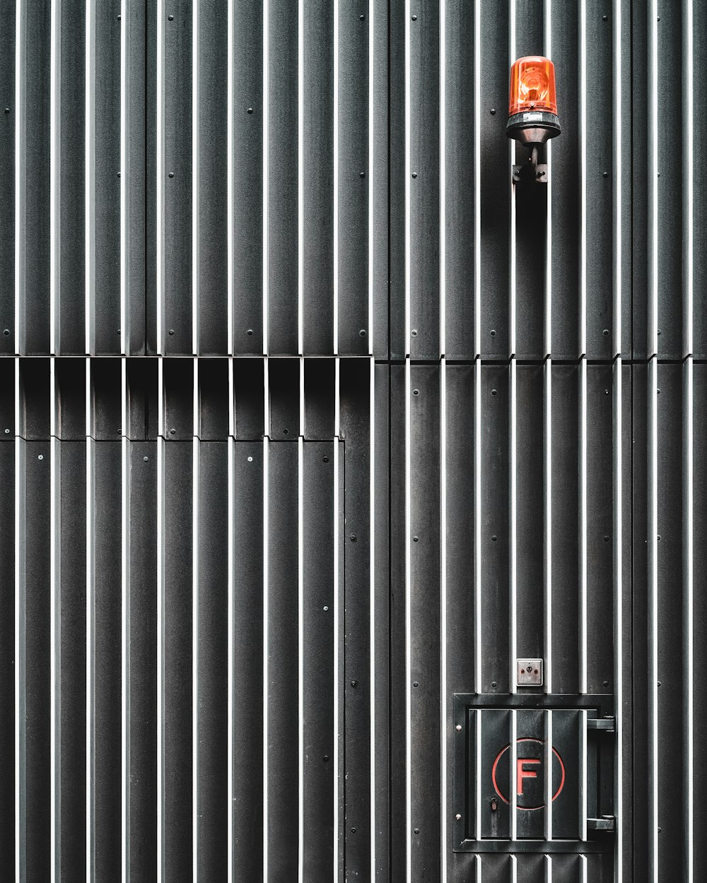 black and red fire extinguisher on gray metal wall