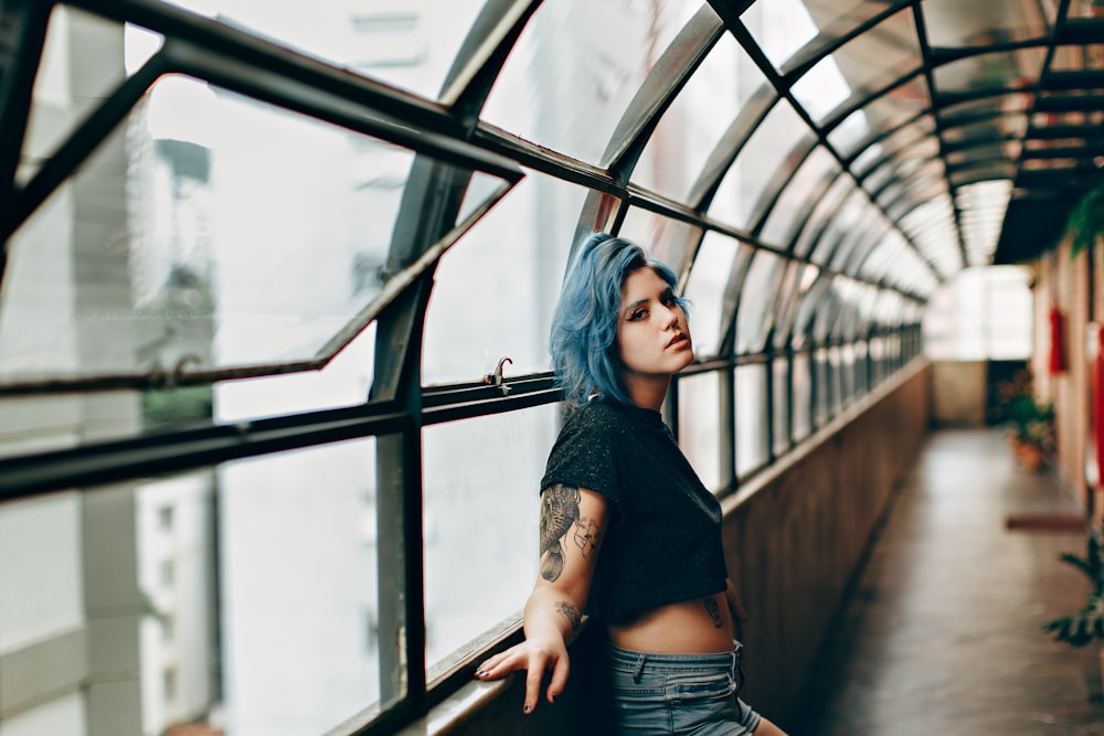 woman in black shirt and blue denim jeans standing on train rail