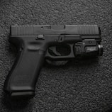 black semi automatic pistol on gray textile