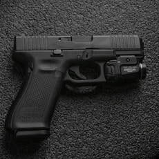 black semi automatic pistol on gray textile