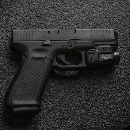 black semi automatic pistol on gray textile