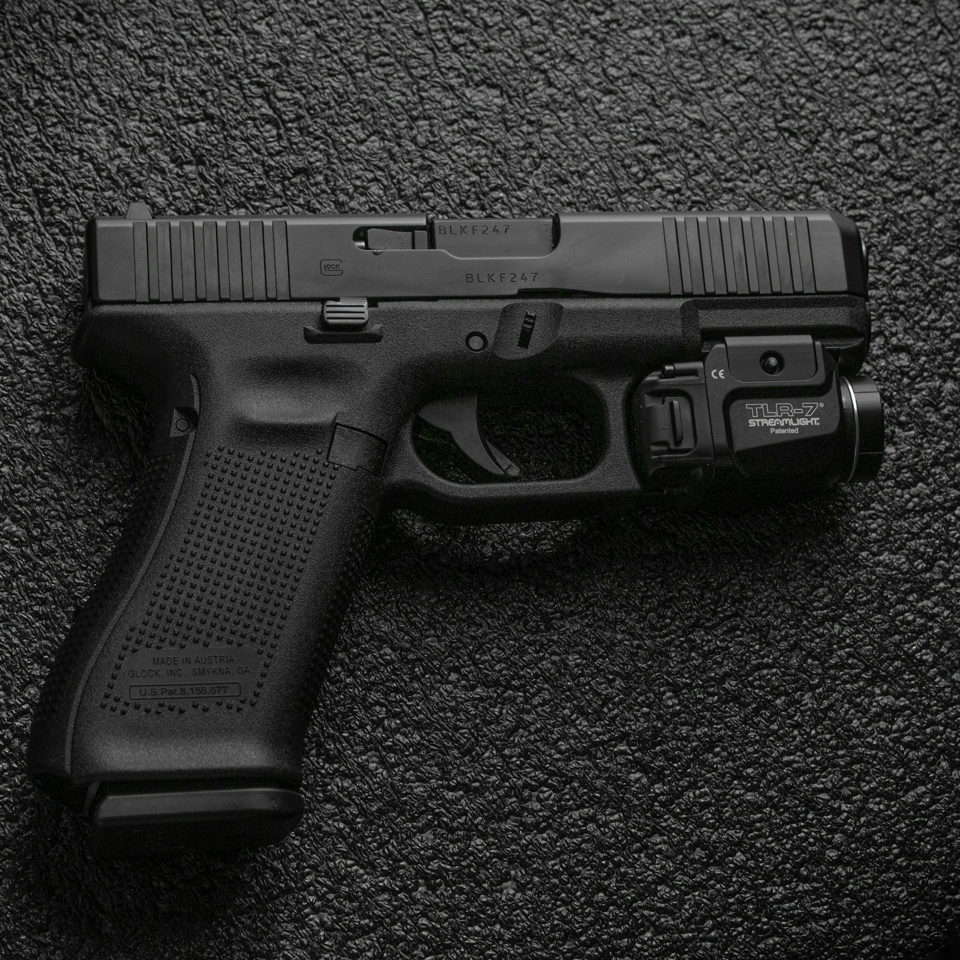 black semi automatic pistol on gray textile