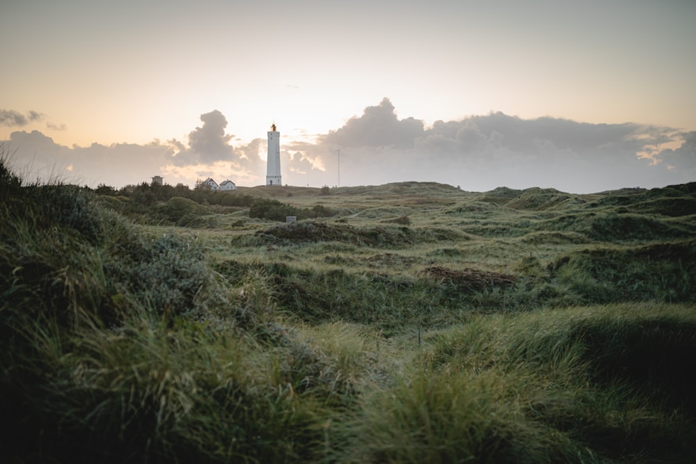 white lighthouse on green grass field during daytime