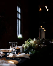 A beautifully set dining table with crystal glasses and candlelight in a sophisticated banquet hall.