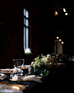 A beautifully set dinner table with vintage silverware, crystal glasses, and candlelight capturing the essence of a 1920s Paris soirée.