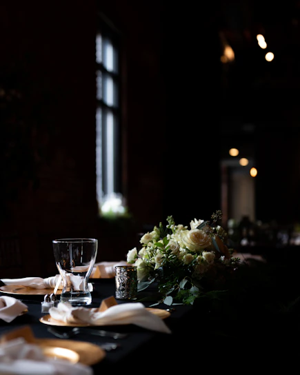 A beautifully set dinner table with vintage silverware, crystal glasses, and candlelight capturing the essence of a 1920s Paris soirée.