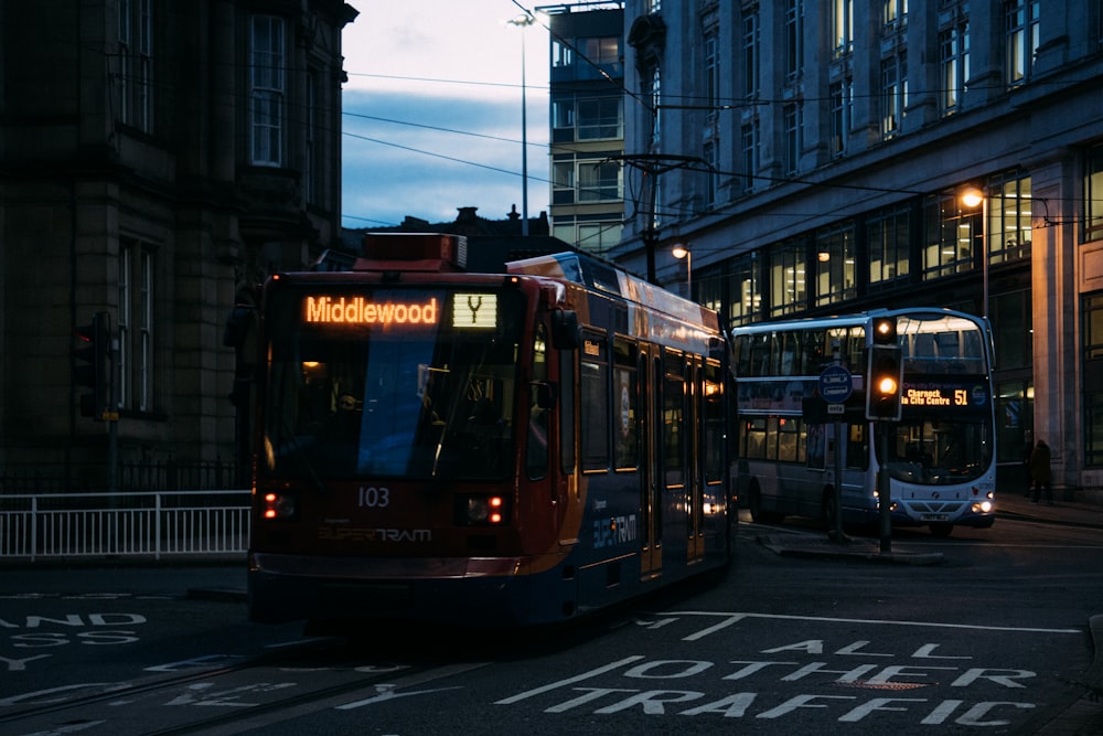 red and black tram on road during night time