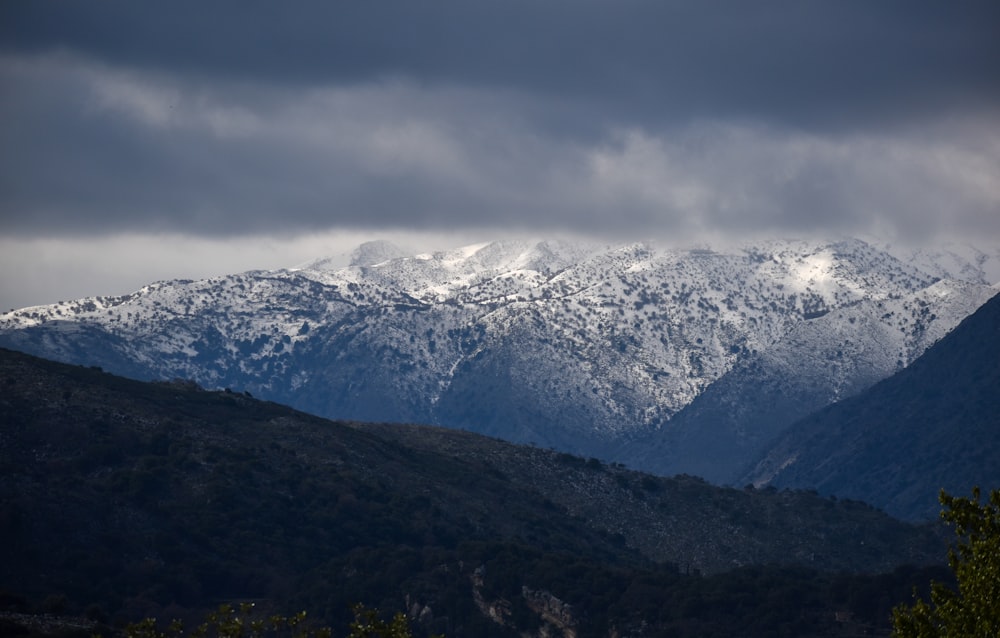 snow covered mountain under cloudy sky during daytime