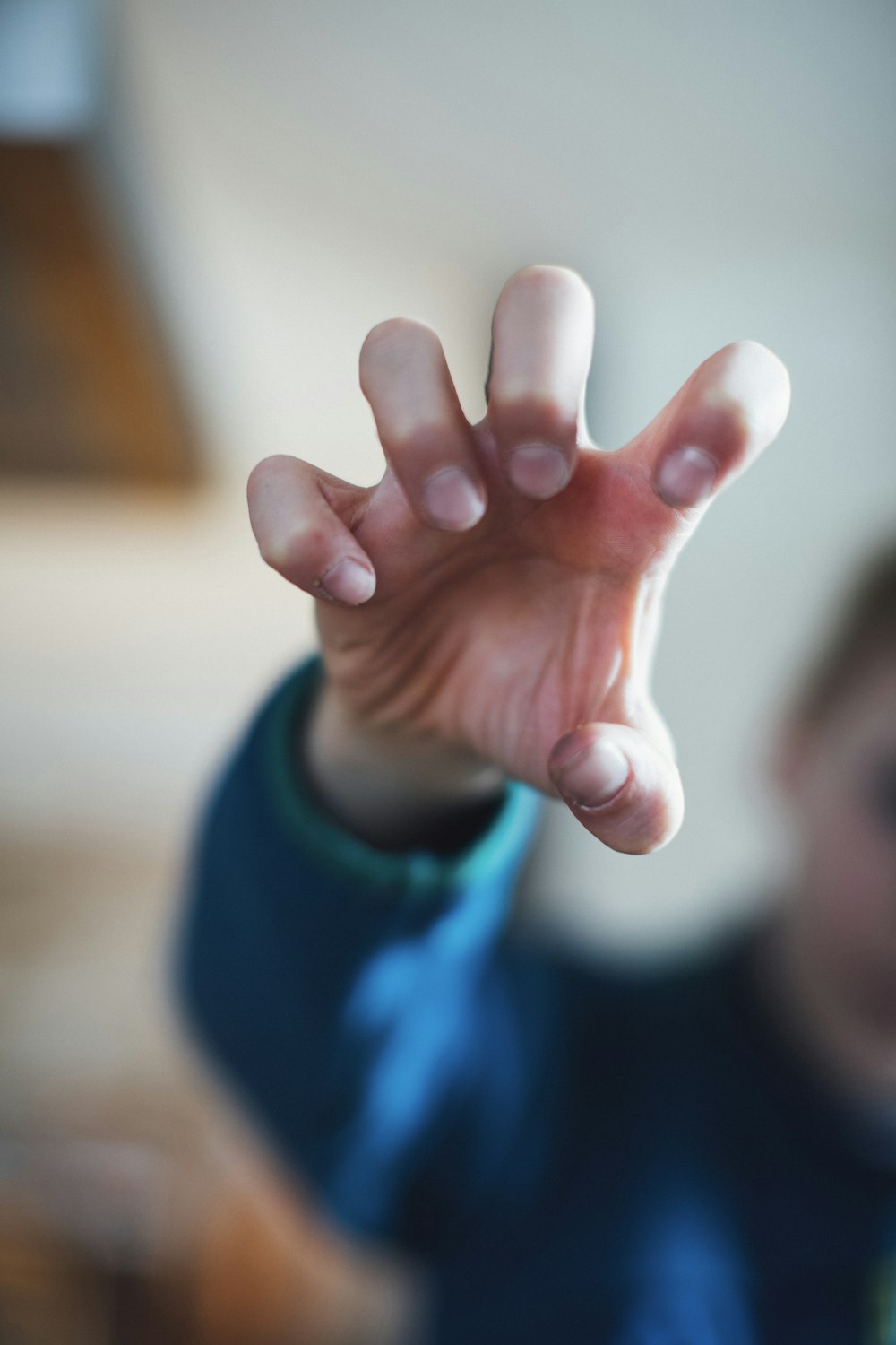 Person im blauen Langarmhemd mit rechter Hand