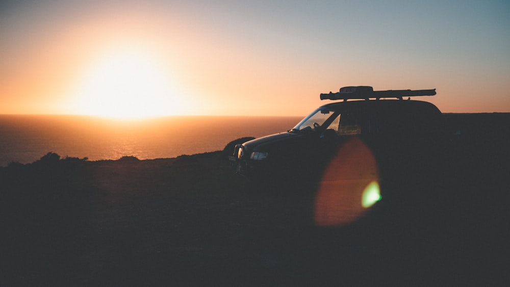 black suv on brown sand during sunset